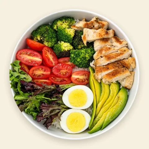 VIVA Golden Golden Chicken Bowl from VIVA Bowls Miami, seen from above: tender grilled chicken over fluffy quinoa with creamy avocado, egg, roasted broccoli, cherry tomatoes and crisp radish